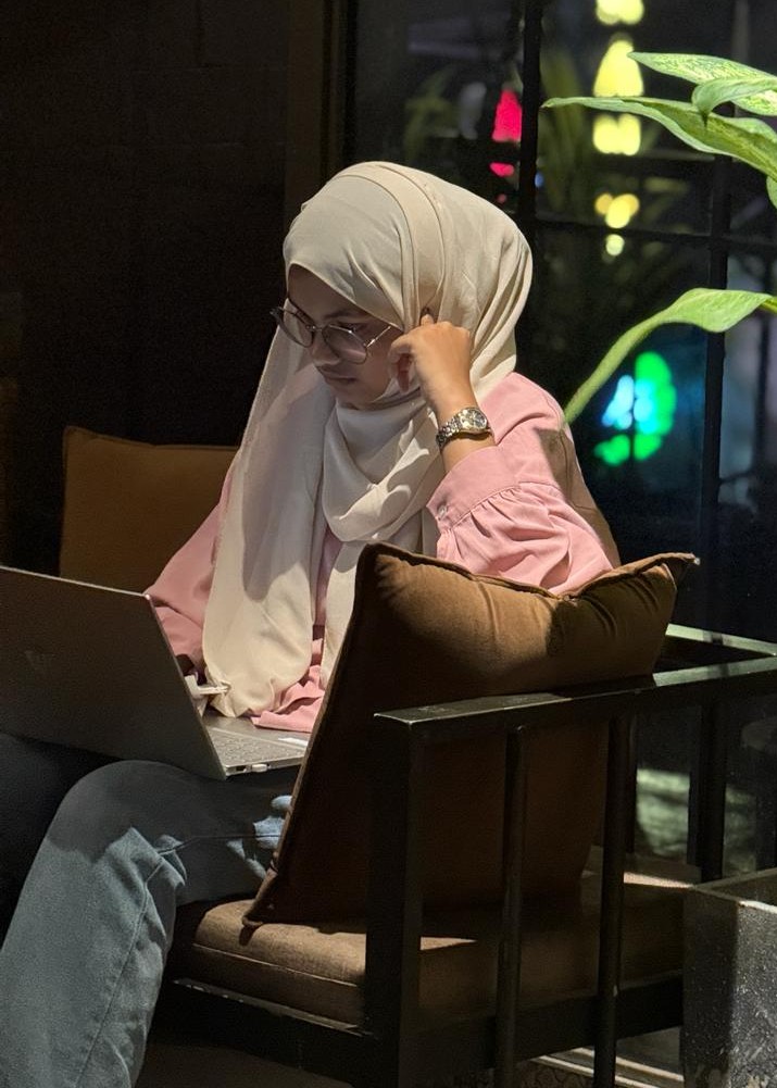 Aami working on a laptop in a cafe